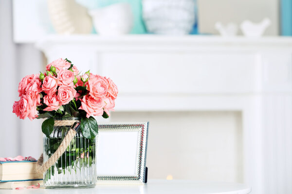 Beautiful rose in vase on table in room