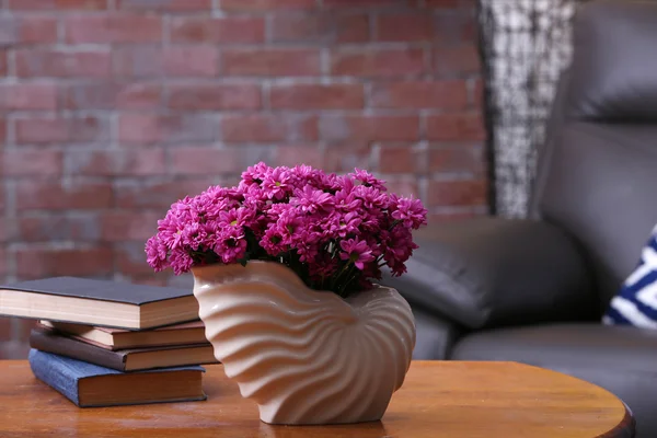 Mooie bloemen in vaas op tafel in de kamer — Stockfoto