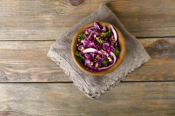 Röd kål och persilja sallad i skål på träbord — Stockfoto