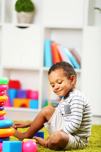 Kleiner Junge spielt mit seinem Spielzeug im Zimmer — Stockfoto