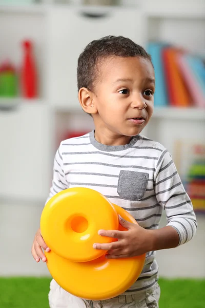 Маленький хлопчик грає зі своїми іграшками в кімнаті — стокове фото