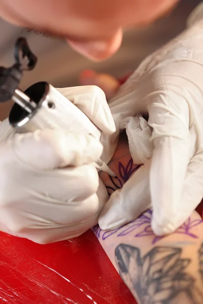 Tatuagem profissional fazendo tatuagem na mão do cliente — Fotografia de Stock