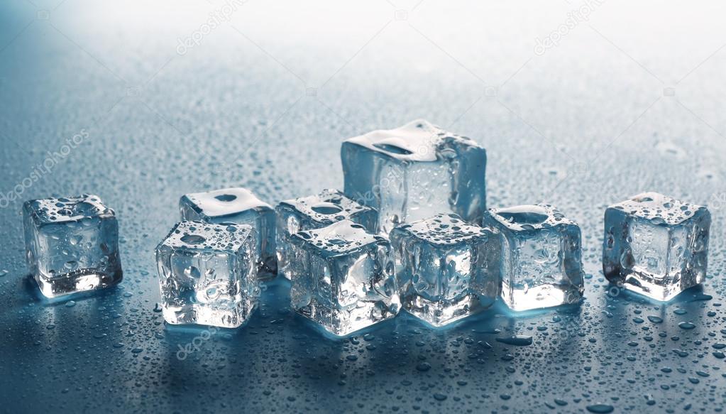 Melting ice cubes with drops around, close up