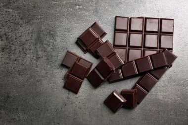 Koyu gri arka plan üzerinde koyu çikolata parçaları
