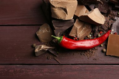 Biber ahşap arka plan üzerinde siyah çikolata parçaları