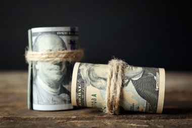 Koyu arka plan önünde ahşap masa dolar rulo