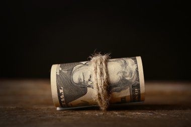 Koyu arka plan önünde ahşap masa dolar rulo