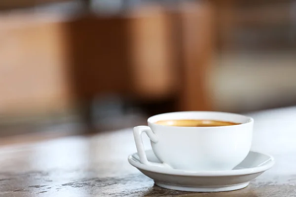 Чашка кофе в таблице на разряженном фоне — стоковое фото