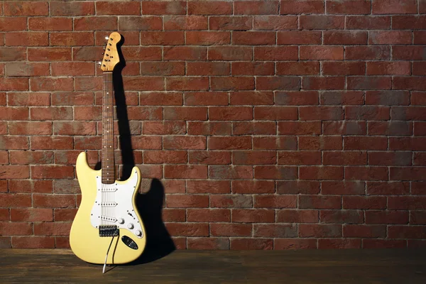 Gitarr på tegel vägg bakgrund — Stockfoto