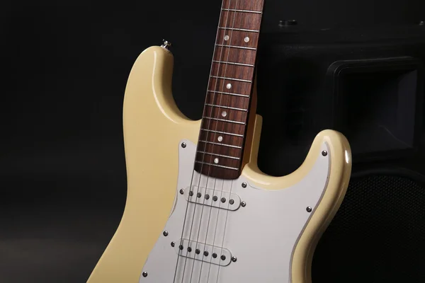 Elektrische gitaar met muziekmateriaal op donkere achtergrond — Stockfoto