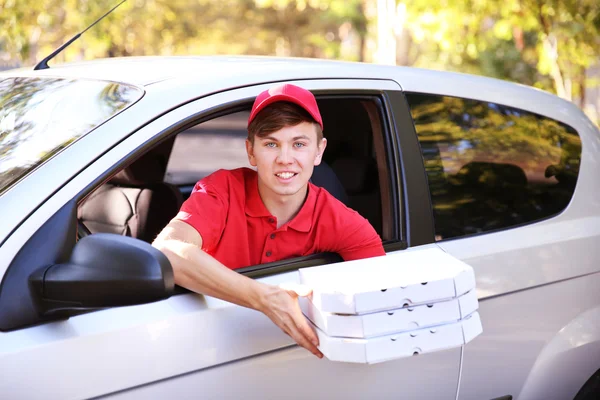 Pizza springpojke i bil — Stockfoto