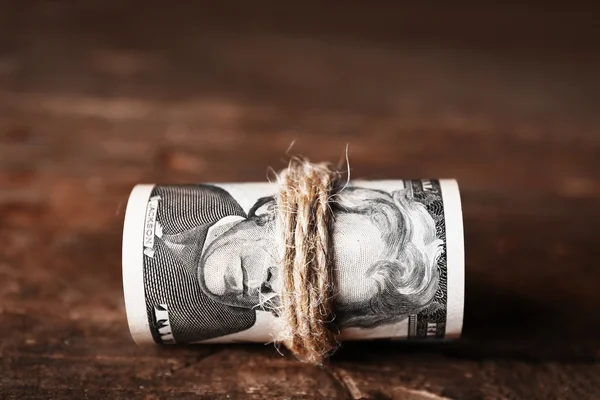 Dollars roll on wooden background — Stock Photo, Image