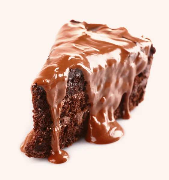 Schokolade auf ein Stück Kuchen gegossen isoliert auf weiß — Stockfoto