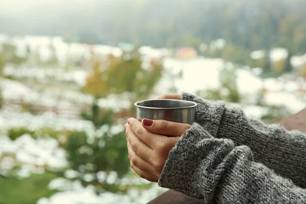 Ruka držící šálek kávy na pozadí hory — Stock fotografie