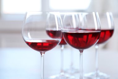 Tablo parlak arka plan üzerinde kırmızı şarap gözlük