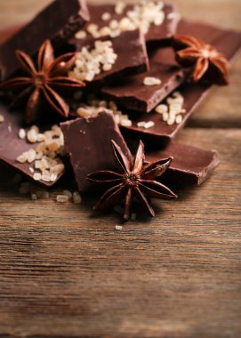 İle baharat ahşap arka plan üzerinde siyah çikolata parçaları