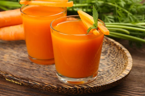 Gläser Karottensaft mit Gemüse auf dem Tisch aus nächster Nähe — Stockfoto