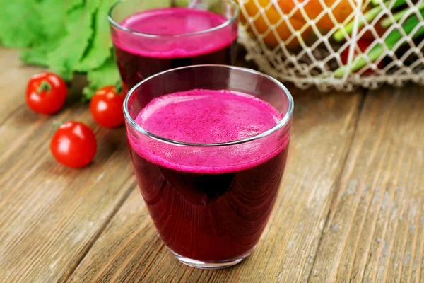 Los vasos del jugo de remolacha con hortalizas a la mesa se acercan — Foto de Stock