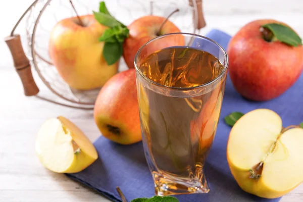 Стакан яблочного сока с фруктами и свежей мяты на столе крупным планом — стоковое фото