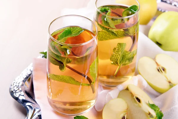 Gläser Apfelsaft mit Früchten und frischer Minze auf dem Tisch aus nächster Nähe — Stockfoto