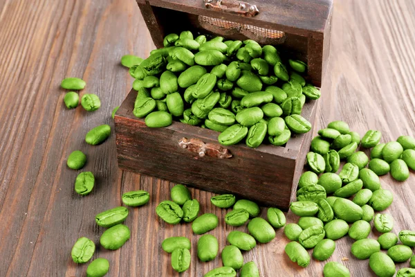 Koffie bonen in borst op houten tafel close-up — Stockfoto