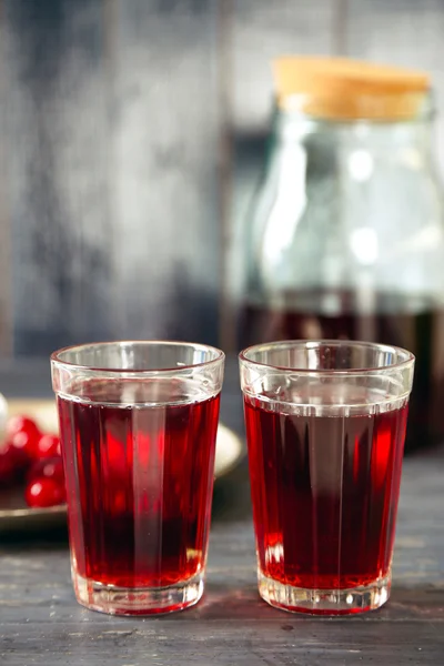 Сладкий домашний вишневый сок на столе, на цветном деревянном фоне — стоковое фото