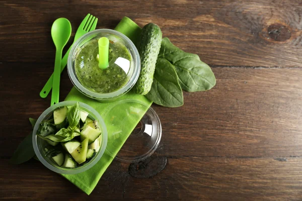 Salada de legumes e frutas verdes e bebida fresca saudável em copos de plástico em fundo de madeira. Conceito de dieta colorida — Fotografia de Stock