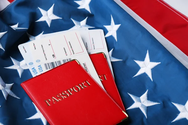 Passaportes, bilhetes deitados na bandeira americana — Fotografia de Stock