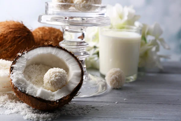 코코넛 부스러기와 밝은 배경에 색 나무 테이블에 신선한 코코넛 사탕 — 스톡 사진