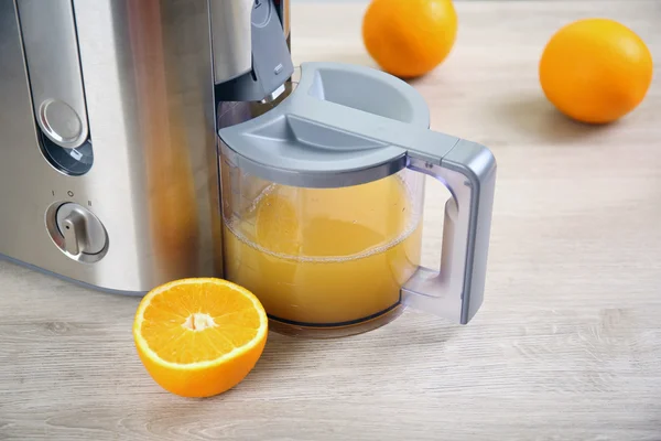 Juicer y jugo de naranja en la mesa de la cocina —  Fotos de Stock