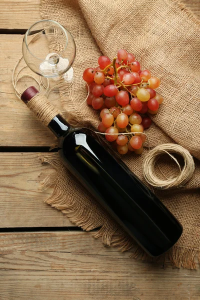 Fles wijn en druivenmost op houten tafel — Stockfoto