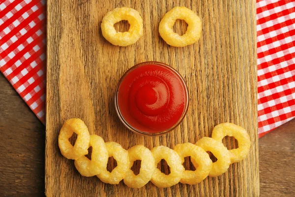 Chips rings with sauce on cutting board — Stock Photo, Image