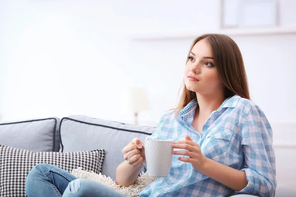 Mujer joven bebiendo té en casa — Foto de Stock