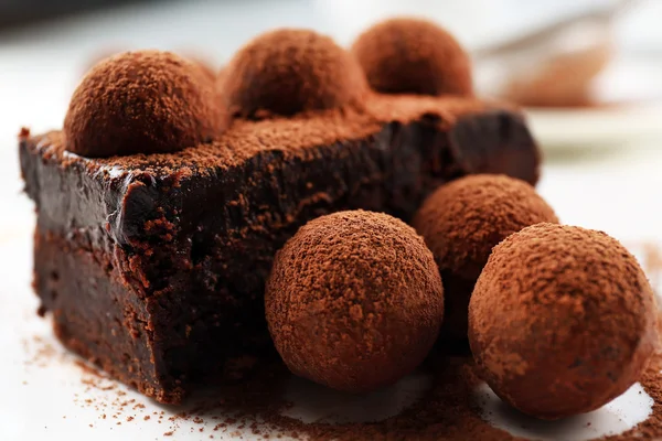 Rebanada de pastel de chocolate con una trufa en el primer plano del plato — Foto de Stock