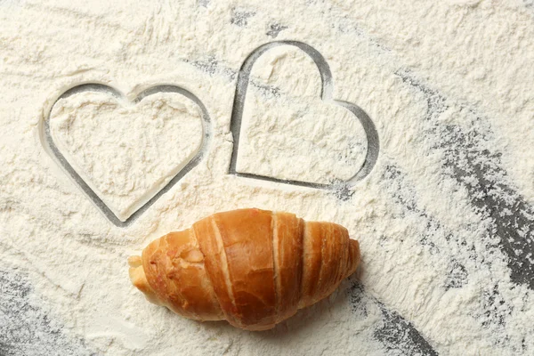 Srdce z mouky a čerstvé croissanty na dřevěné pozadí — Stock fotografie