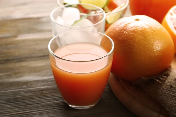 Jus jeruk dengan es dan buah segar di papan potong — Stok Foto