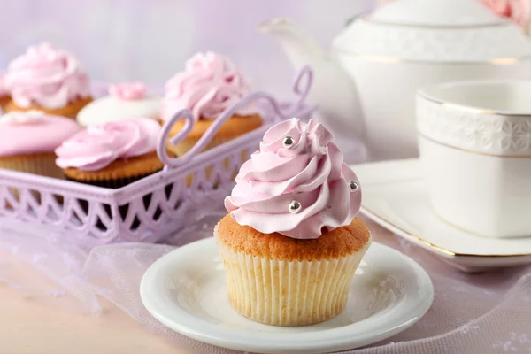 Gustoso cupcake su piattino, su sfondo chiaro — Foto Stock