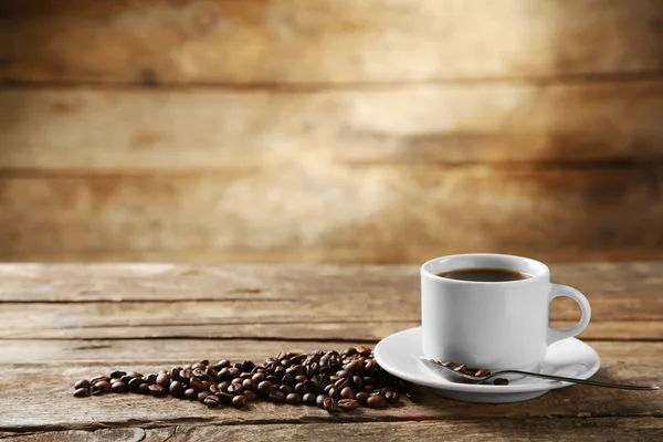 Xícara de grãos de café e café em fundo de madeira — Fotografia de Stock