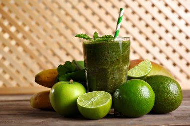 Meyveler ve otlar ahşap zemin üzerine yeşil sağlıklı meyve suları