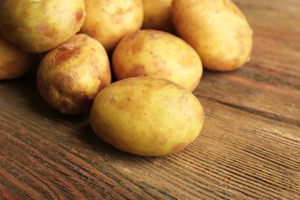 Batatas jovens na mesa de madeira perto — Fotografia de Stock