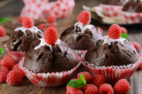 Leckere Schokoladen-Cupcakes mit Beeren und frischer Minze auf Holztisch aus nächster Nähe — Stockfoto