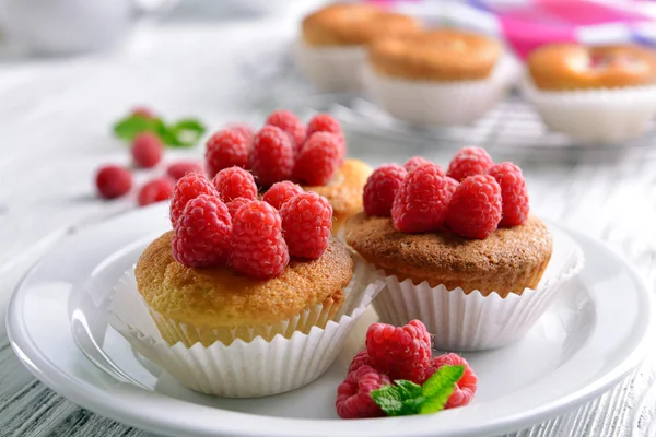 Delicious cupcakes with berries and fresh mint on wooden table close up — Stock Photo, Image