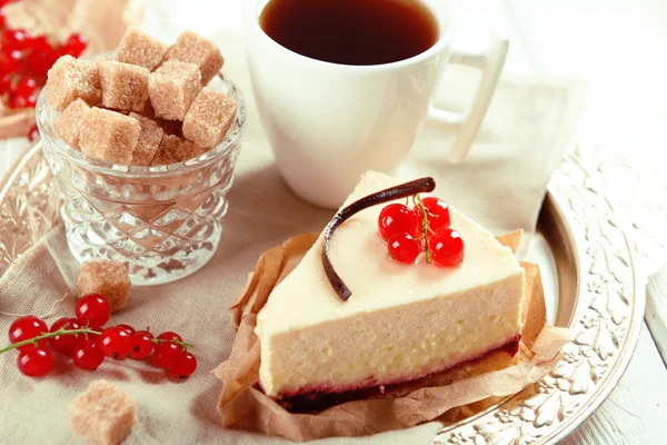 Вкусный чизкейк с ягодами и чашкой чая на столе. — стоковое фото