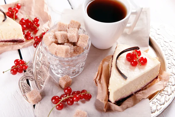 Smakelijke cheesecake met bessen en kopje thee op tafel close-up — Stockfoto