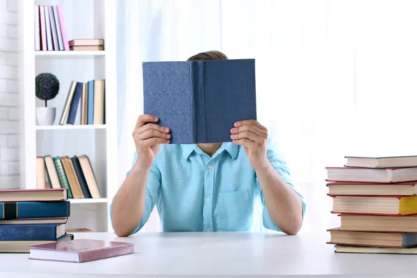 Joven leyendo libro en la mesa —  Fotos de Stock