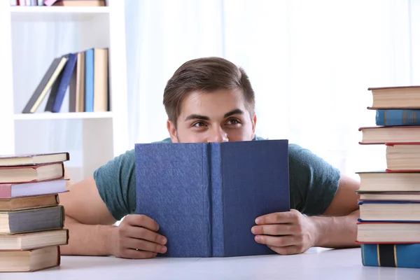 Joven leyendo libro en la mesa — Foto de Stock