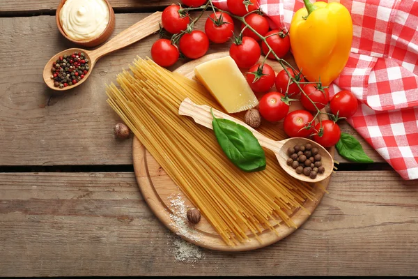 Nudelspaghetti mit Tomaten, Käse und Basilikum auf rustikalem Holzgrund — Stockfoto