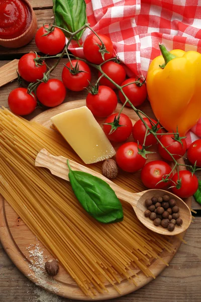 Pasta spaghetti with tomatoes, cheese and basil on rustic wooden  background — Stock Photo, Image