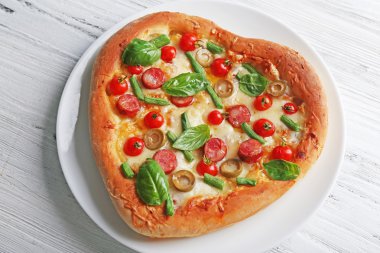 Ahşap arka plan üzerinde pizza lezzetli kalp şeklinde