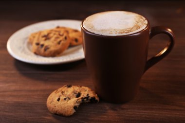 Fincan kahve süt köpüğü ile ve ahşap zemin üzerine çikolata kırıntıları ile tanımlama